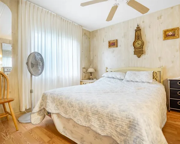 a bedroom with a bed and a painting on the wall