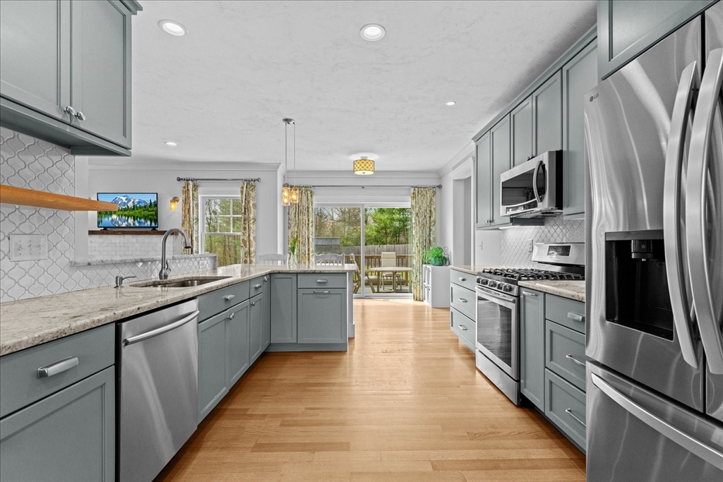 50 Quabbin Path Sutton, MA 01590 - Photo 14 of 42 a large kitchen with stainless steel appliances granite countertop a stove top oven a sink dishwasher a refrigerator and cabinets with wooden floor