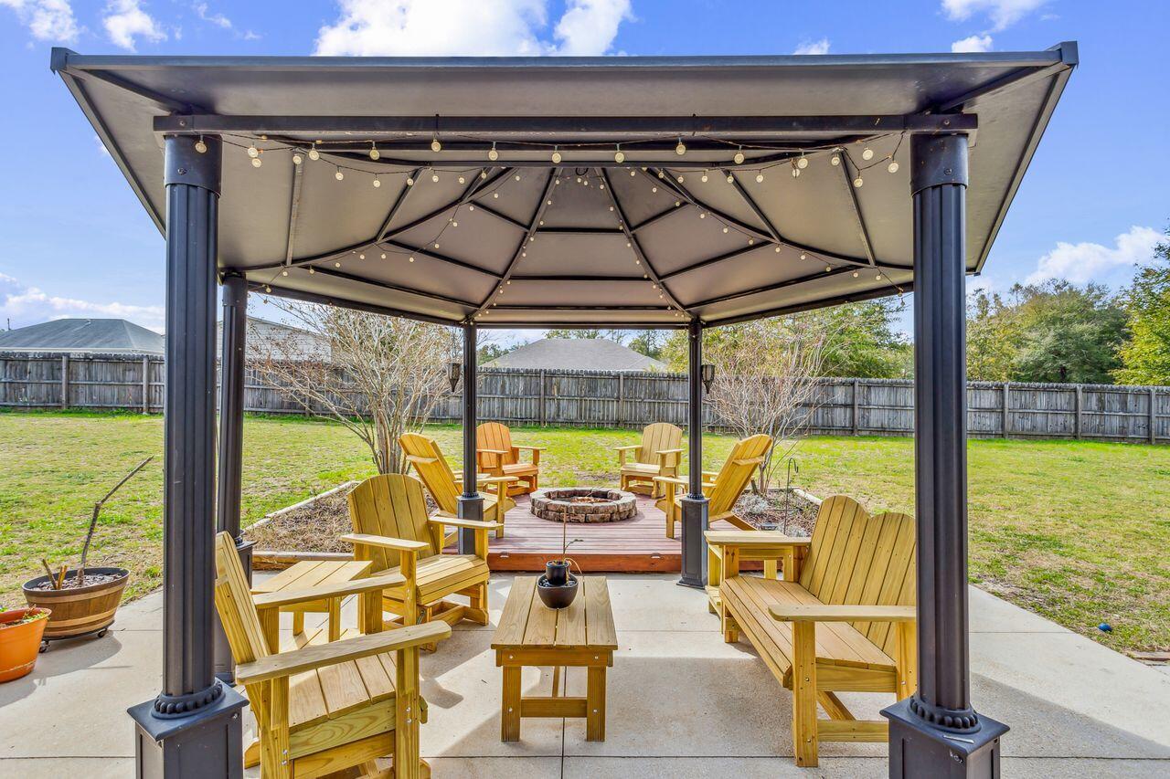 6256 Evan Circle Crestview, FL 32536 - Photo 37 of 46 a view of a swimming pool with a table chairs and wooden floor