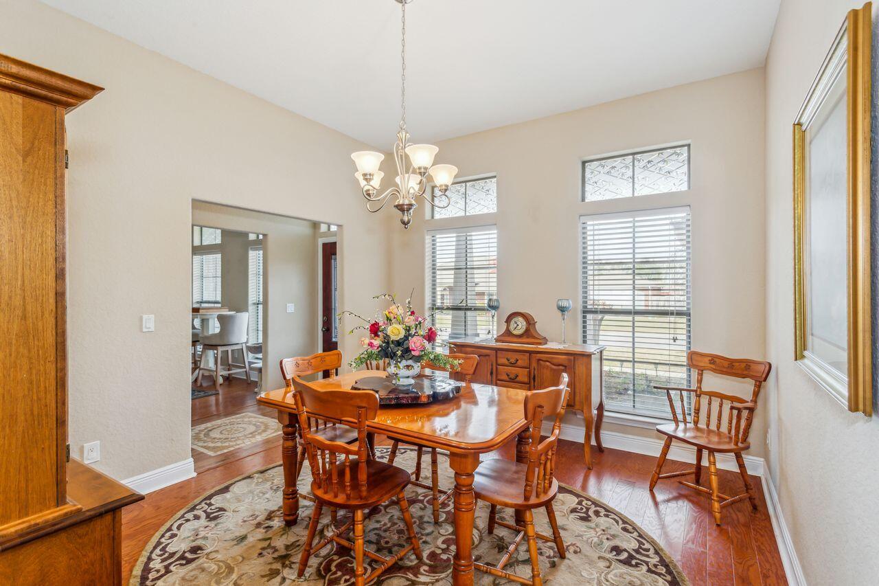 6256 Evan Circle Crestview, FL 32536 - Photo 7 of 46 a dining room with wooden floor a chandelier a wooden table and chairs
