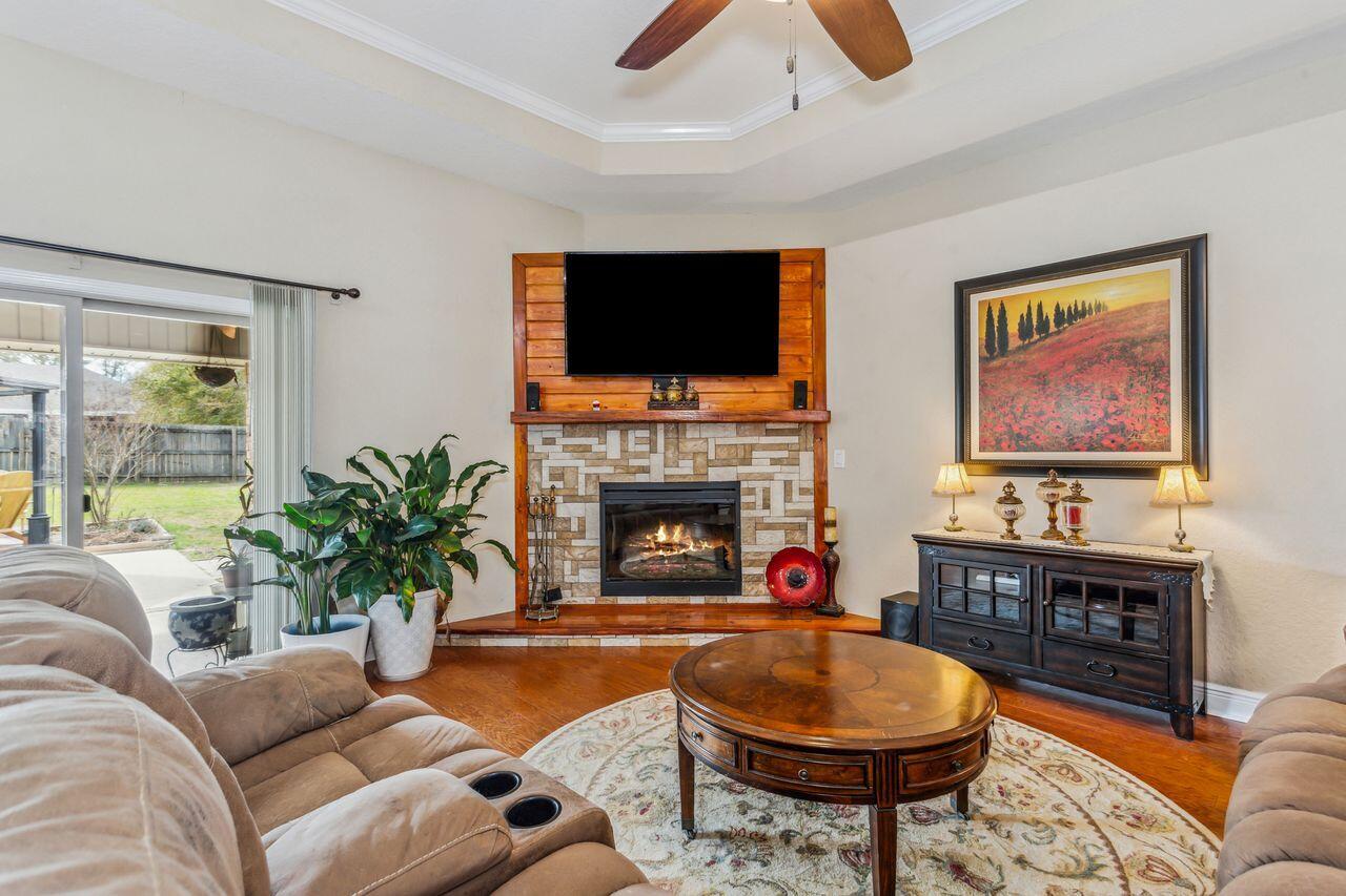 6256 Evan Circle Crestview, FL 32536 - Photo 9 of 46 a living room with furniture a flat screen tv and a fireplace