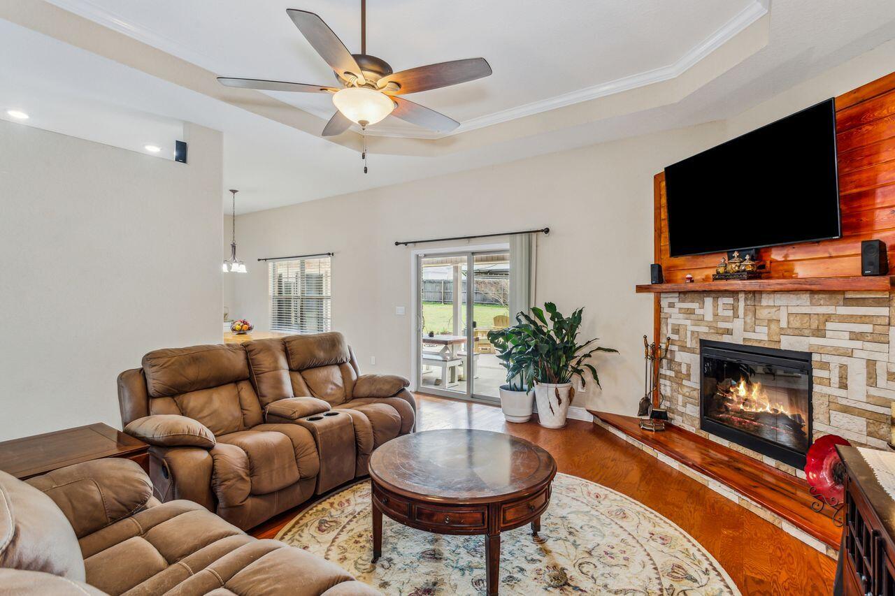 6256 Evan Circle Crestview, FL 32536 - Photo 10 of 46 a living room with furniture a flat screen tv and a fireplace