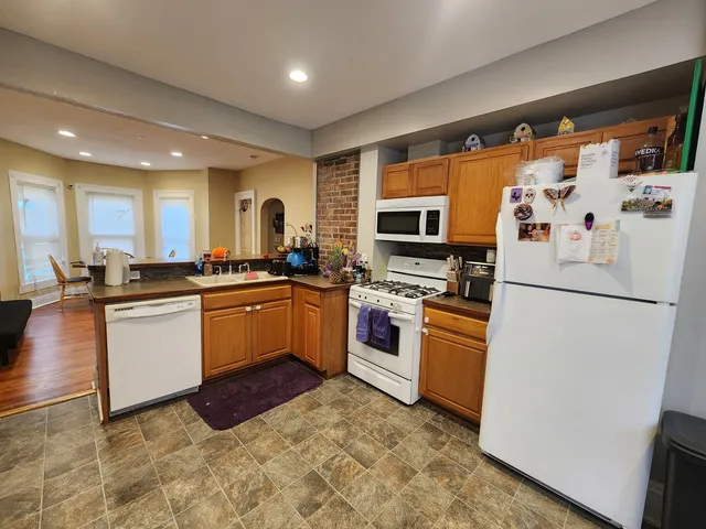 a kitchen with granite countertop appliances a sink and a refrigerator