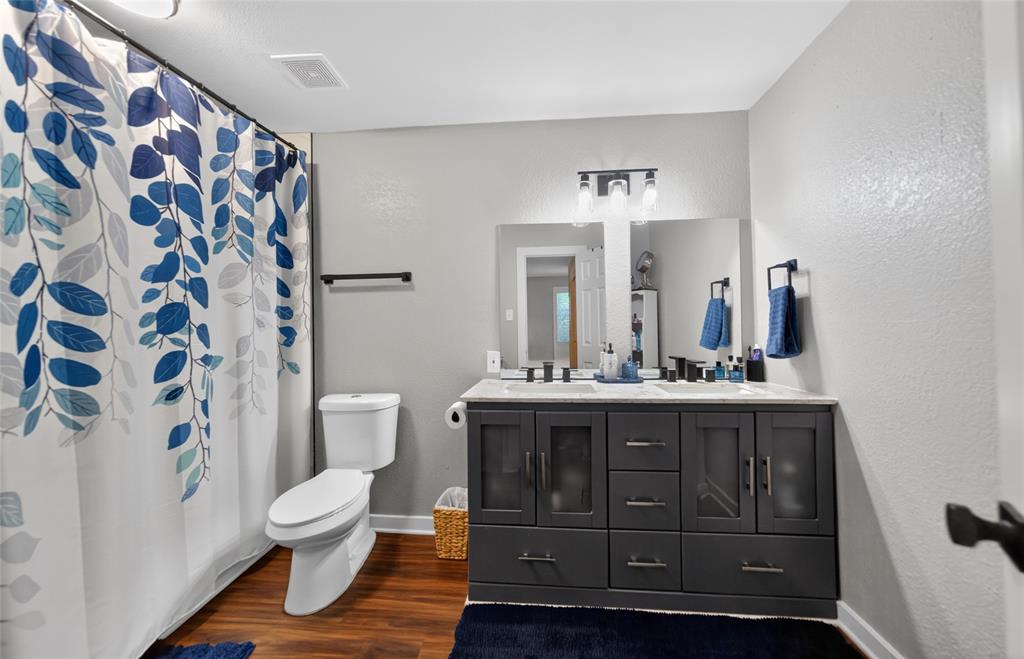 614 Colonial Drive Athens, TX 75751 - Photo 17 of 26 a spacious bathroom with a toilet a sink and a mirror
