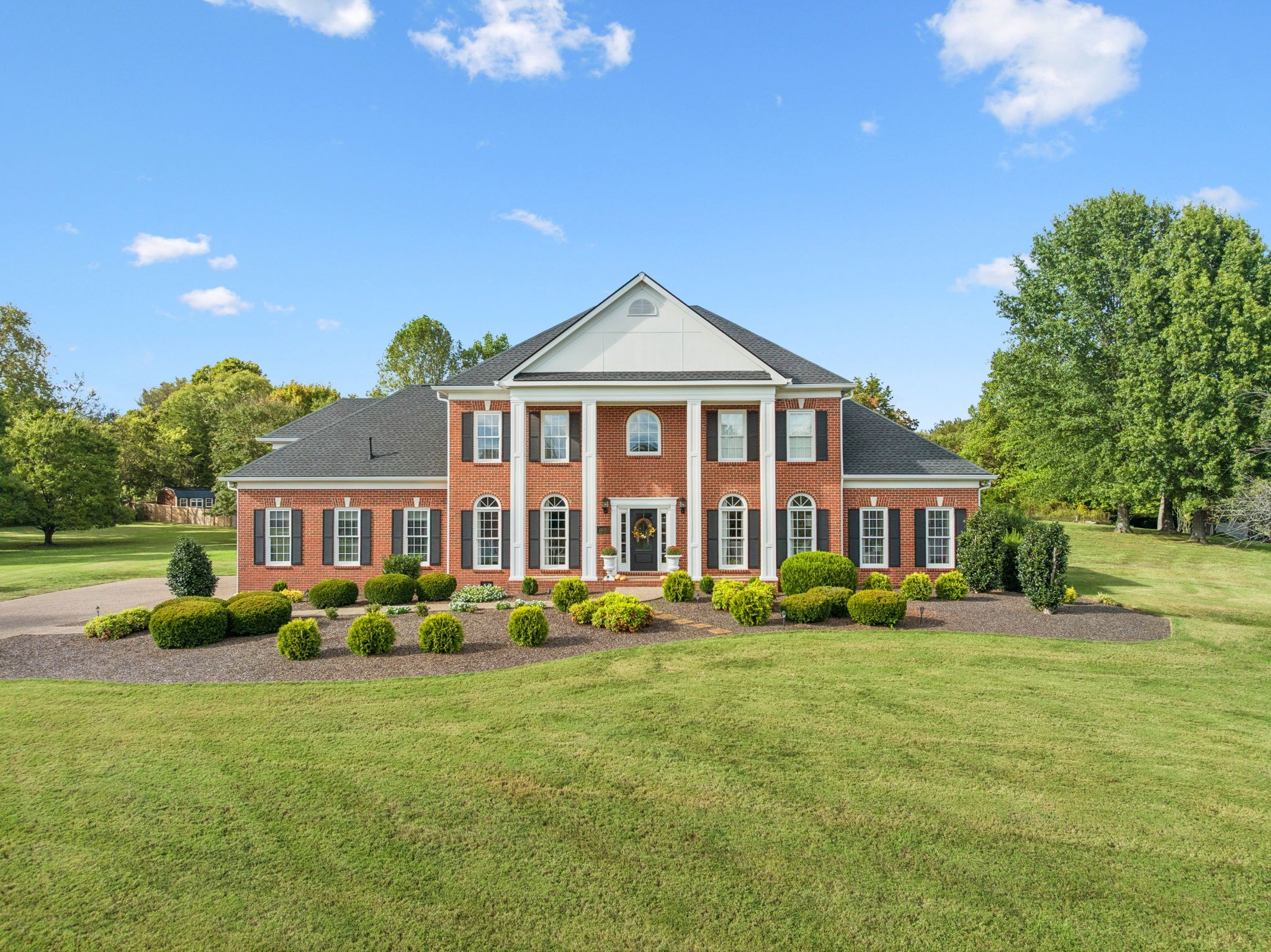 a front view of a house with a garden