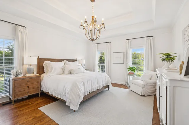 a spacious bedroom with a bed and a chandelier