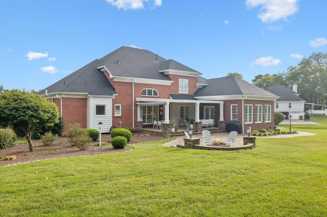 a view of a green yard with large trees