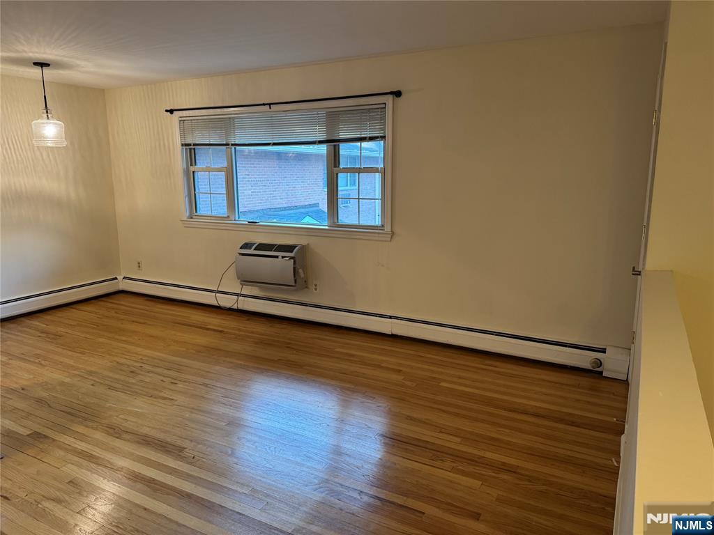 511 Washington Drive Ramsey, NJ 07446 - Photo 5 of 8 a room with wooden floor and white walls