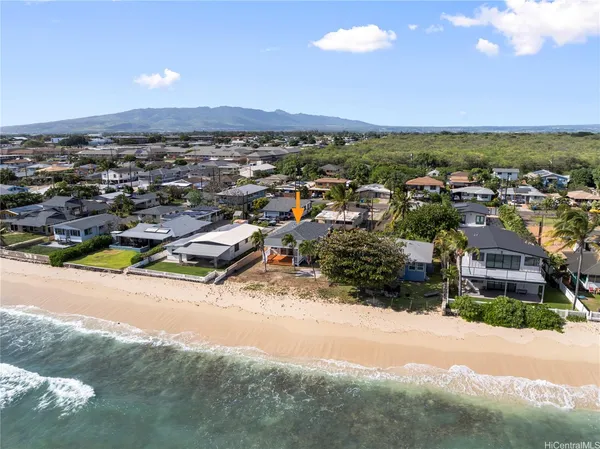 an aerial view of residential houses with outdoor space and ocean view