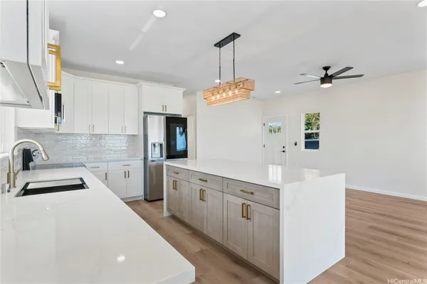 a kitchen with kitchen island a sink a counter space appliances and cabinets