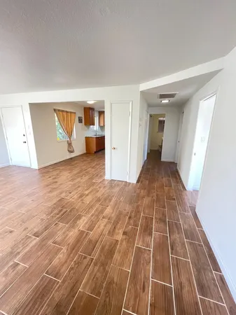 a view of empty room with wooden floor