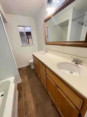 a spacious bathroom with a tub sink and mirror
