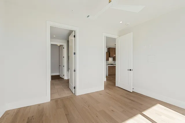 a view of a hallway with wooden floor and closet