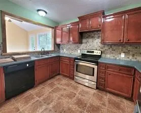 a kitchen with a sink stove top oven and cabinets
