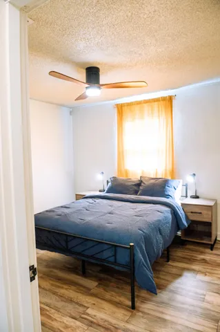 a bedroom with a bed and wooden floor