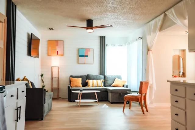 a living room with furniture wooden floor and a large window