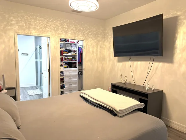 a bedroom with a bed and a flat screen tv