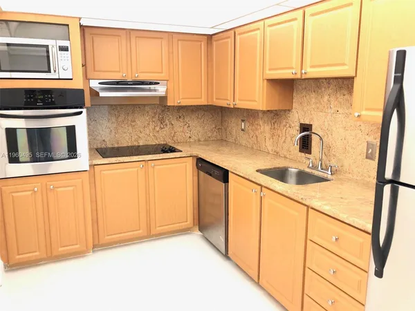 a kitchen with granite countertop a refrigerator and a sink