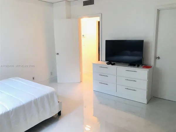 a bedroom with a bed and a flat screen tv