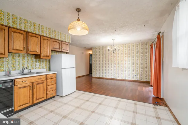 a view of a kitchen with a sink and dishwasher with wooden floor