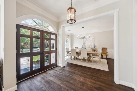 a view of dining room and livingroom with furniture wooden floor a chandelier