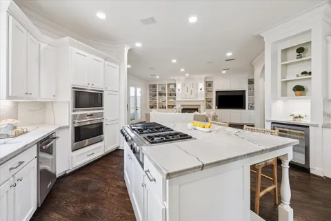 a kitchen with stainless steel appliances kitchen island granite countertop a stove and a sink