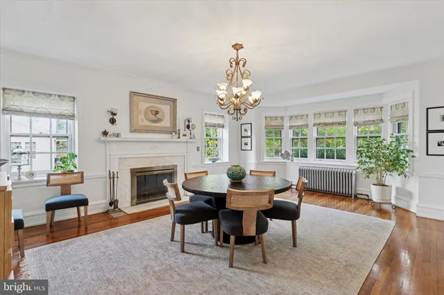 a dining room with furniture a fireplace and wooden floor