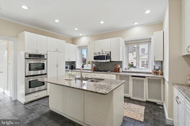 a kitchen with kitchen island granite countertop a sink stove and refrigerator