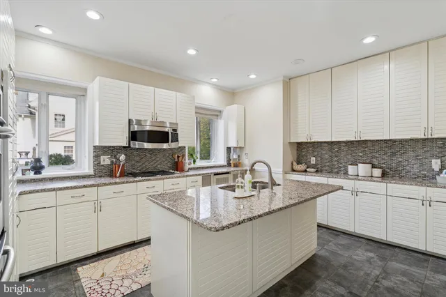 a kitchen with stainless steel appliances granite countertop a sink a stove and cabinets