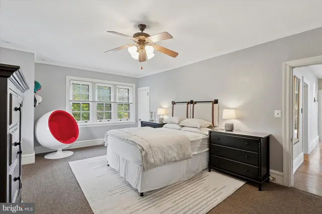 a bedroom with a large bed and wooden floor