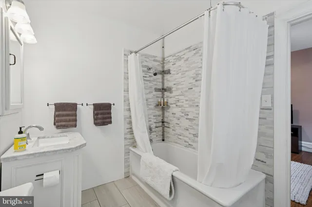 a bathroom with a bathtub a sink a toilet and shower