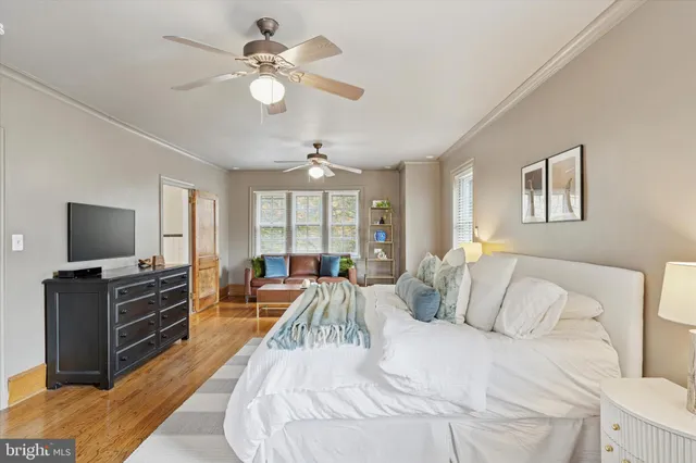 a spacious bedroom with a bed and a flat screen television