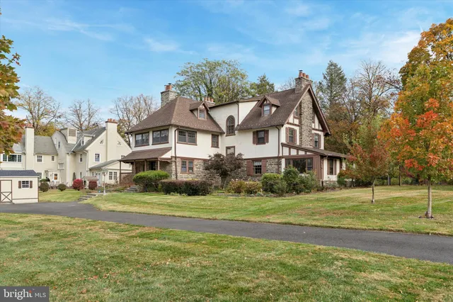 a view of a big house with a big yard and large trees
