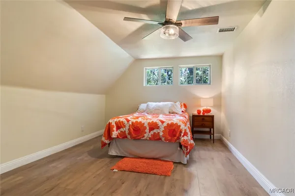 a bedroom with a bed and a ceiling fan