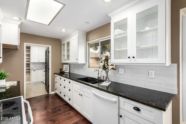 a large white kitchen with stainless steel appliances granite countertop a sink and stove