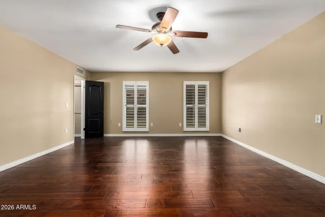 a view of an empty room with a chandelier fan