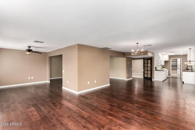 a view of an empty room with wooden floor and a fireplace