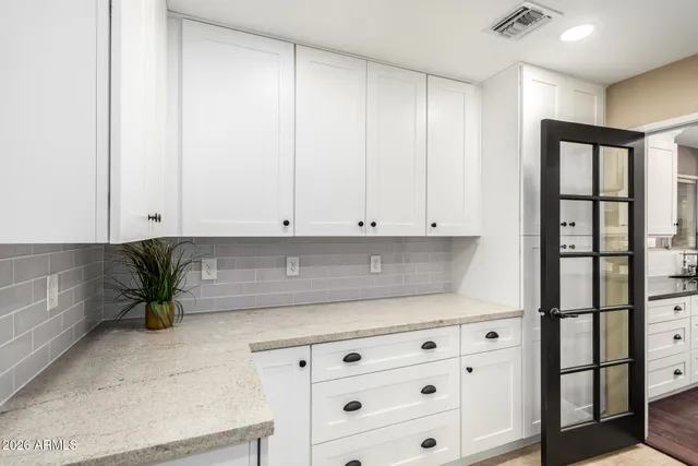 a kitchen with granite countertop white cabinets and white appliances