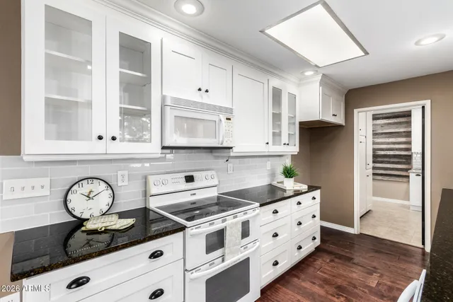a kitchen with stainless steel appliances a stove a sink cabinets and wooden floor