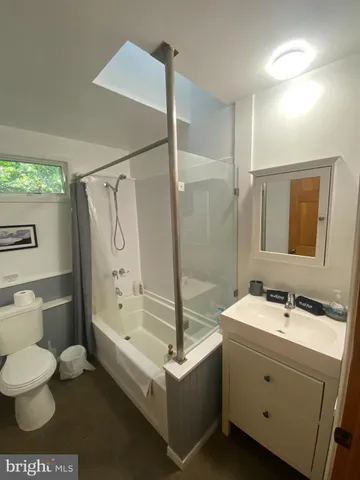 a bathroom with a bathtub sink mirror and toilet