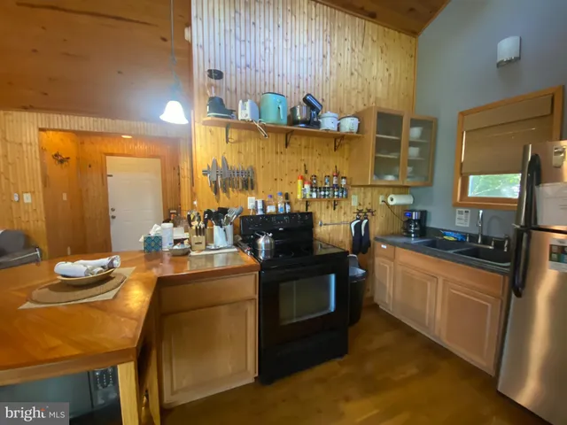 a kitchen with sink refrigerator dining table and chairs