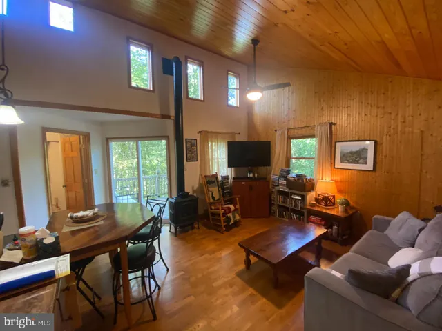a living room with furniture a flat screen tv and a window