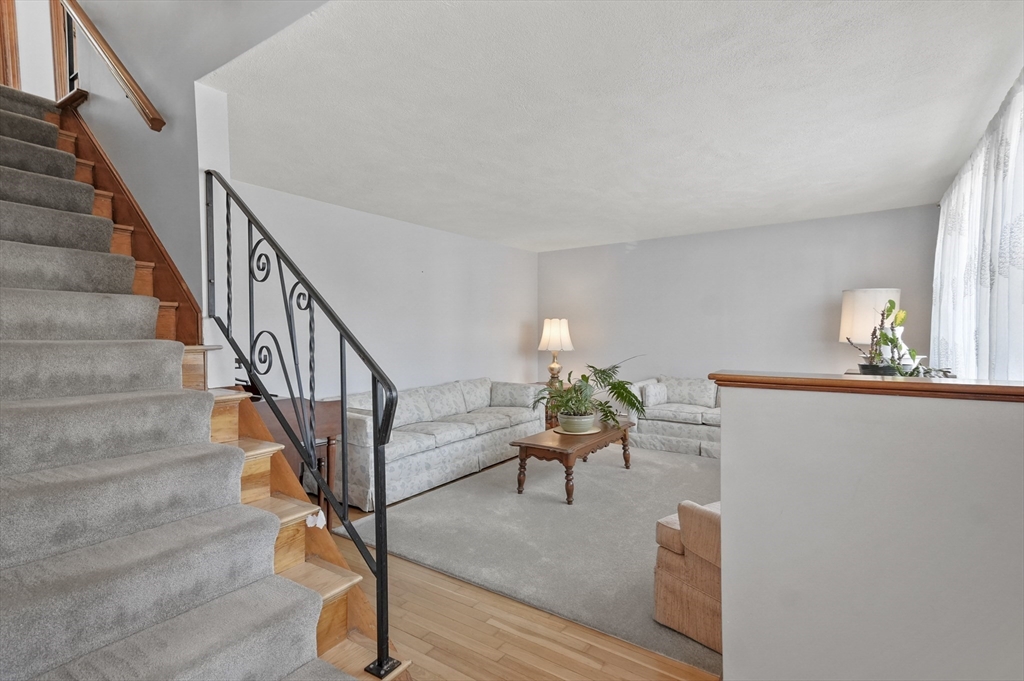 95 Gregory Street Waltham, MA 02451 - Photo 11 of 36 a living room with wooden floor and a stairs