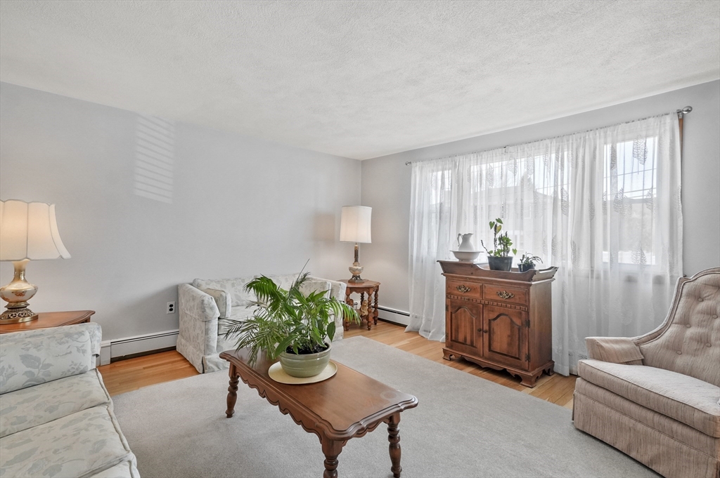 95 Gregory Street Waltham, MA 02451 - Photo 12 of 36 a living room with furniture a window and a lamp