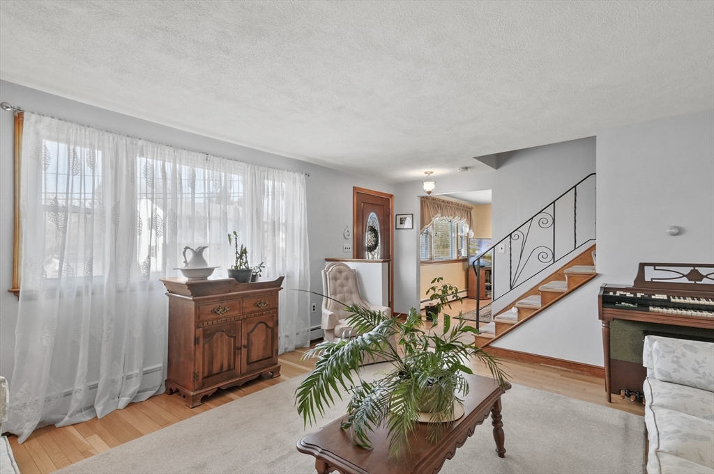 95 Gregory Street Waltham, MA 02451 - Photo 13 of 36 a living room with furniture a piano and wooden floor