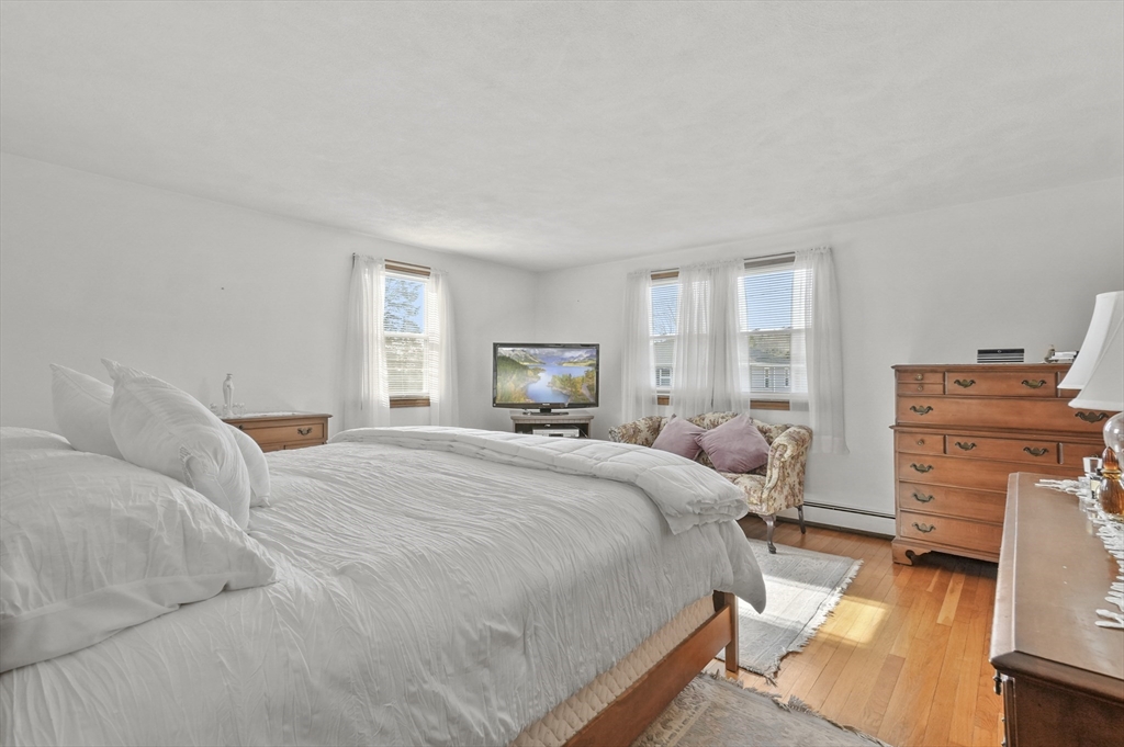 95 Gregory Street Waltham, MA 02451 - Photo 16 of 36 a bedroom with a bed and wooden floor