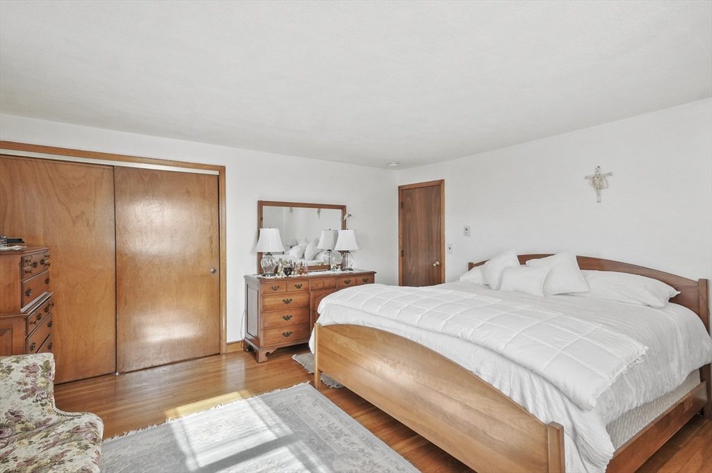 95 Gregory Street Waltham, MA 02451 - Photo 17 of 36 a bedroom with a bed and wooden floor