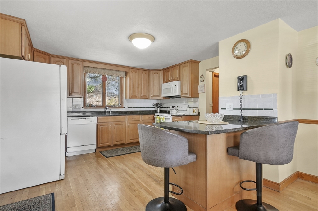 95 Gregory Street Waltham, MA 02451 - Photo 7 of 36 a kitchen with granite countertop a sink cabinets and window