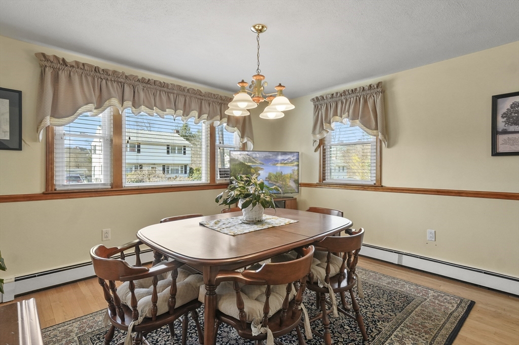 95 Gregory Street Waltham, MA 02451 - Photo 9 of 36 a dining room with furniture a chandelier and wooden floor