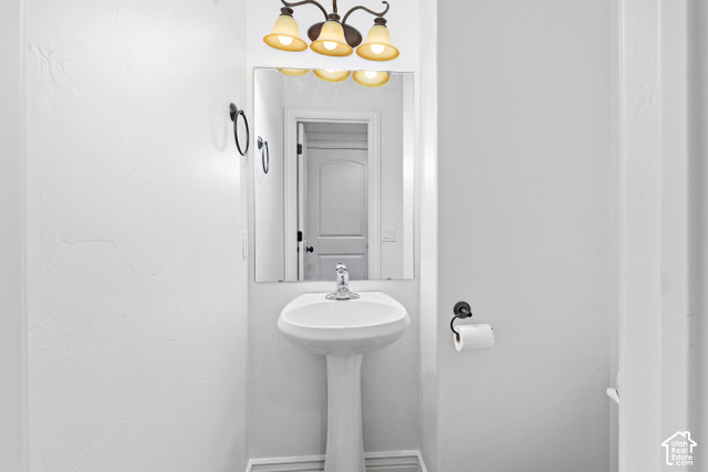 2092 Cres Drive South Mapleton, UT 84664 - Photo 11 of 26 Pedestal sink with chrome faucet, wall-mounted mirror, and decorative light fixture